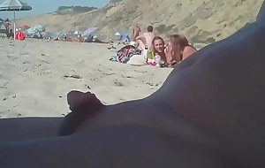 Person with a small rod on the nudist beach